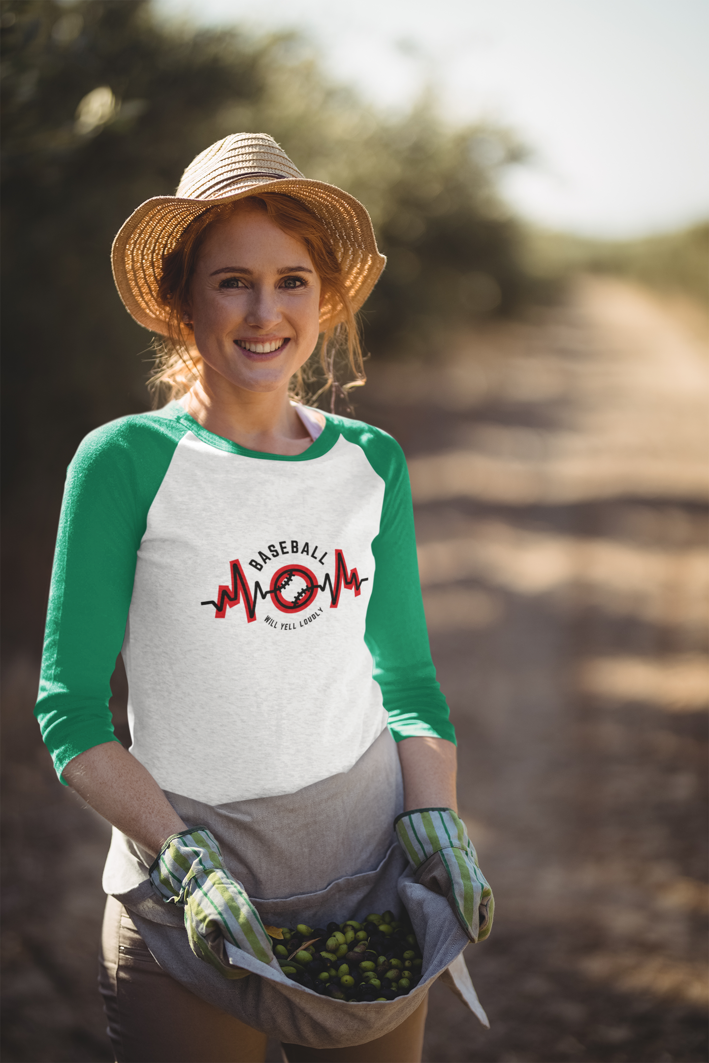 Woman standing in bean field wearing hat and 3/4 length Raglan tee that says Baseball Mom